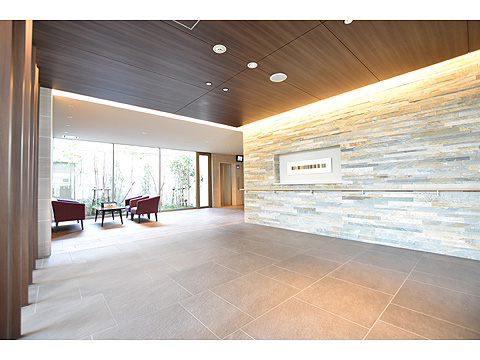 エントランス 壁に天然石を配した落ち着いたエントランスホール