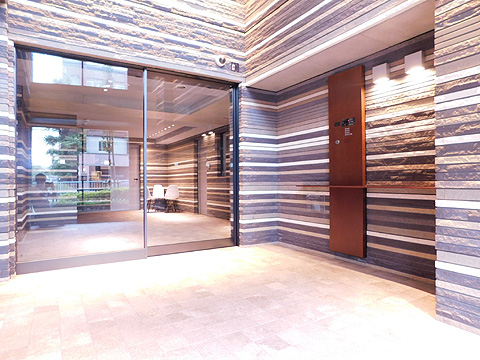 エントランス 地中から出土したような錆鉄色の壁面を用いて、洞