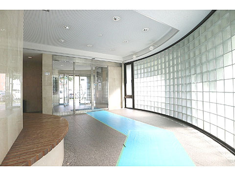 ロビー 自然の光が差し込むガラスブロックが弧を描く、柔らかく