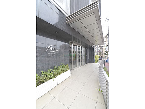 現地外観写真　アプローチから風除室まで、硬質な御影石で構成